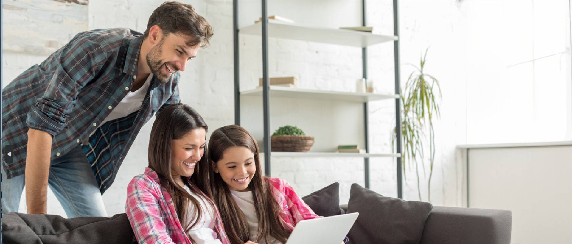 man and woman with girl looking at laptop